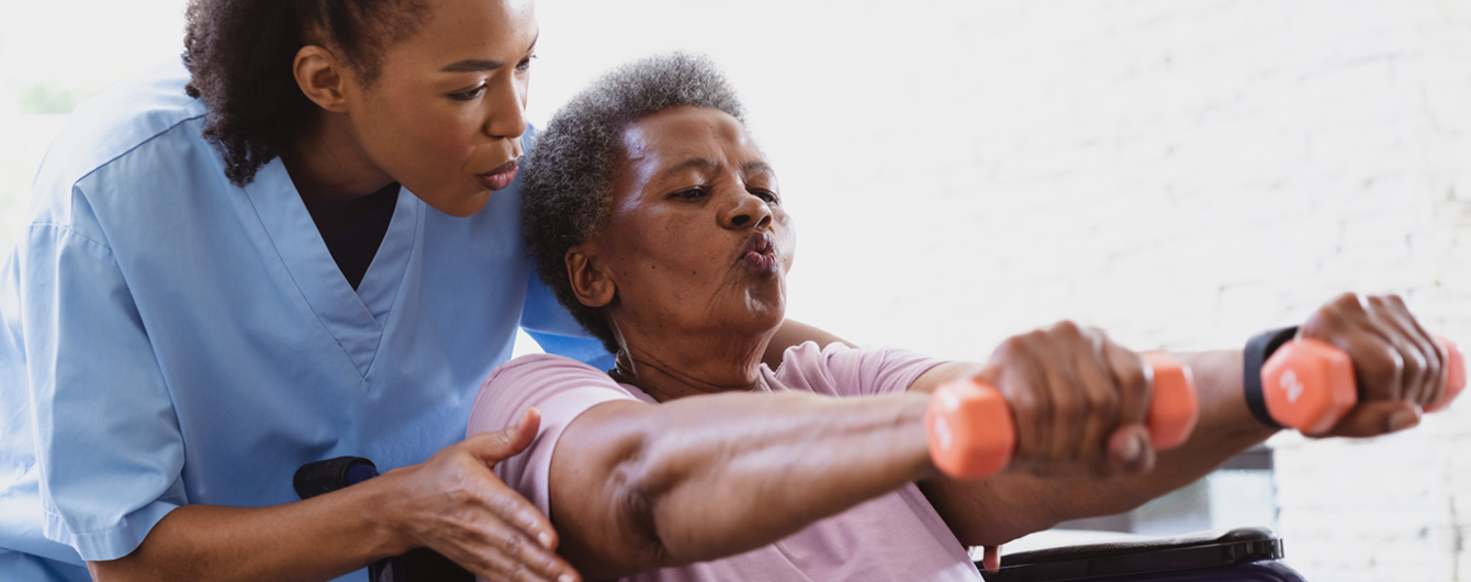 Female CDCP assists a senior female client with arm exercises